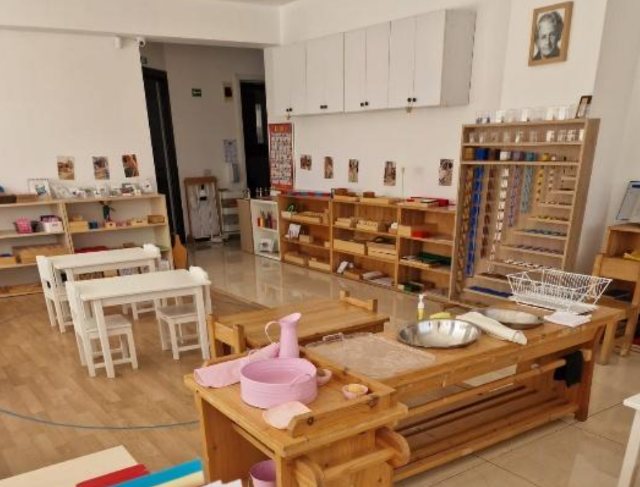 Raft cu material senzorial și de matematică, sub portretul Mariei Montessori