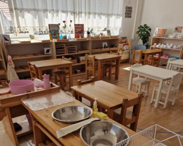 Colț de viață practică cu boluri de inox, ulcioare și rafturi joase cu cărți